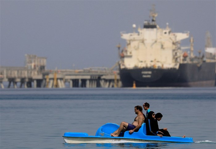 People enjoy the water while container ships park near the El Ain El Sokhna port before entering the Suez Canal, Egypt, 25 September 2020. Reuters/Amr Abdallah Dalsh