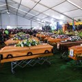 People gather near empty coffins ahead of a mass funeral for victims of an east coast tavern where bodies of youth were found which prompted nationwide grief, in the Eastern Cape province, in East London, South Africa, 6 July 2022. Reuters/Siphiwe Sibeko