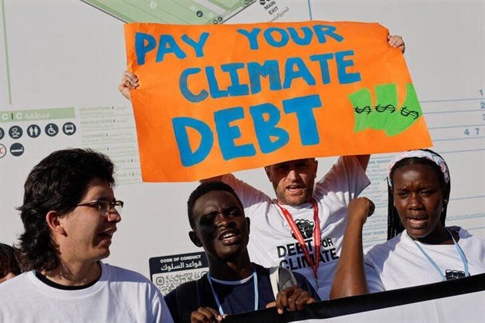 A demonstrator holds a placard as people protest during the COP27 climate summit in Sharm el-Sheikh, Egypt. Source: Reuters/Mohammed Salem