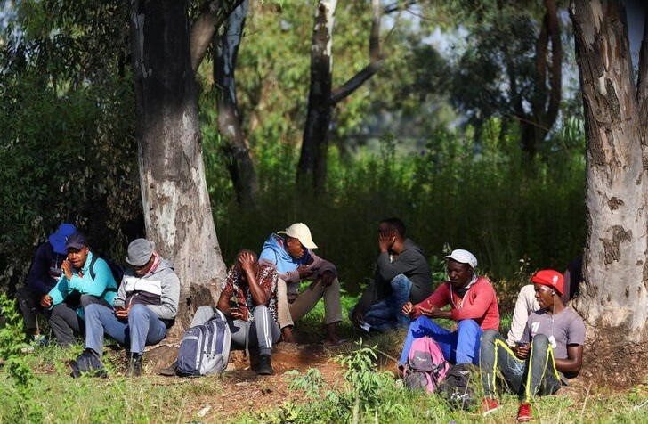 Job seekers wait beside a road for casual work offered by passing motorists in Eikenhof, south of Johannesburg, South Africa, 3 March 2022. Reuters/Siphiwe Sibeko