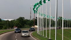 Cars drive past Nigerian national flags in Abuja, Nigeria 12 June 2021. Reuters/Afolabi Sotunde