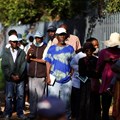 Social grant recipients stand in a queue outside a post office, as joblessness takes its toll in Meadowlands, a suburb of Soweto, South Africa, 24 February 2022. Reuters/Siphiwe Sibeko