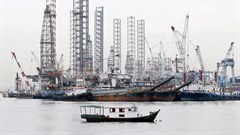 Offshore drilling platforms (rear) stand together at a dock yard near Singapore port. 2015. Source: Reuters/Tim Wimborne