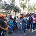 Some of the workers, who were dismissed from the Frimax chip factory in Verulam, Durban, for participating in an unprotected strike last month, wait outside the CCMA. Photo: Tsoanelo Sefoloko / GroundUp