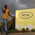 A man walks past an MTN logo outside the company's headquarters in Johannesburg. Source: Reuters/Siphiwe Sibeko
