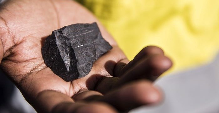 Miner holds a manganese ore sample in South Africa.