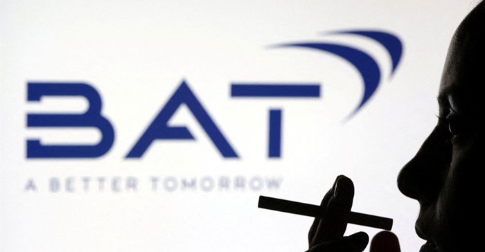 File photo: A woman poses with a cigarette in front of BAT (British American Tobacco) logo in this illustration taken 26 July 2022. Reuters/Dado Ruvic/Illustration/File Photo