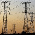 A man walks beneath electricity pylons during frequent power outages caused by its ageing coal-fired plants, in Orlando, Soweto. Source: Reuters/Siphiwe Sibeko