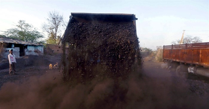 A worker watches as a loader unloads coal at a yard on the outskirts of Ahmedabad. Source: Reuters/Amit Dave