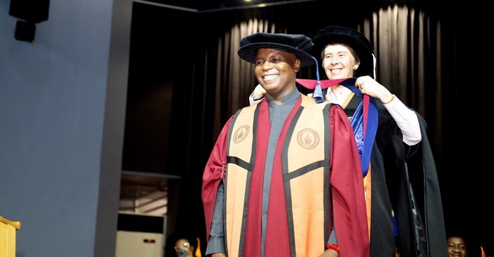 Ikalafeng is robed by Prof Betty van Vuuren. Source: UJ.
