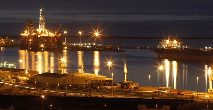 An oil rig lights up Cape Town harbour as the sun sets. The giant floating platforms are becoming regular visitors to the port as the city is marketing itself as the service hub for the lucrative oil fields off the west coast of Africa. Source: Reuters/Mike Hutchings