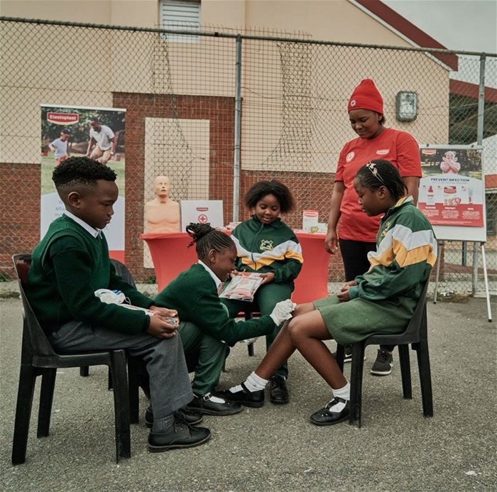 Children from Bonga Primary, Gugulethu, pictured with an Elastoplast Representative.