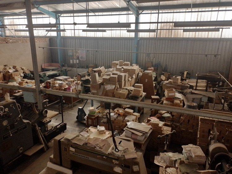 The rooms are full of dusty piles of books and old machinery.