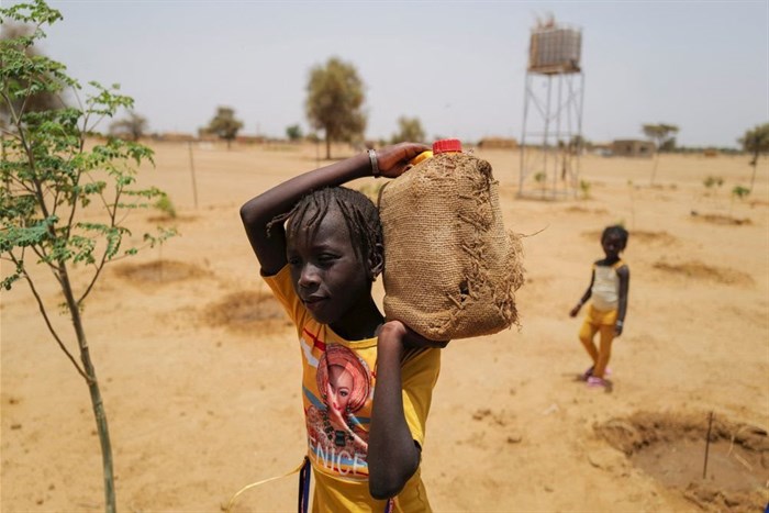 A girl carries a jerrycan filled with water at a Tolou Keur garden in the Walalde department of Podor, in the Great Green Wall of the Sahara and the Sahel area, Senegal, 11 July 2021. Reuters/Zohra Bensemra/File Photo