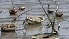 A fisherman walks toward his boat during low tide, in Maputo, 28 September 2010. Reuters/ Goran Tomasevic/File Photo