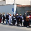 Striking Mister Sweet workers queued on Wednesday for food brought by supporters. Photo: Kimberly Mutandiro / GroundUp