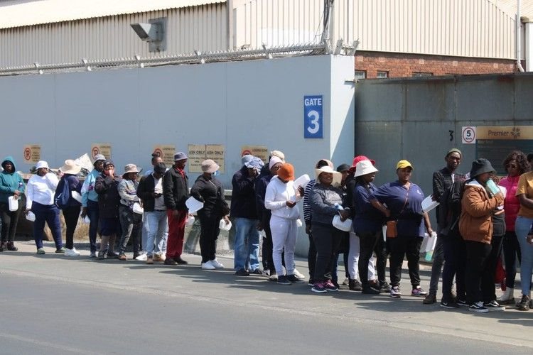 Striking Mister Sweet workers queued on Wednesday for food brought by supporters. Photo: Kimberly Mutandiro / GroundUp