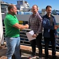 Source: Supplied. Chris Derksen, Rael Philips, James Woolley and Francois van Zyl shake hands on the balcony of Latitude Aparthotel by Totalstay in Sea Point, Cape Town, having just signed the hotel-management agreement.