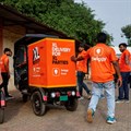Swiggy gig workers assist another worker as he parks an electric three-wheeler delivery scooter during a promotional event in Mumbai. Source: Reuters/Francis Mascarenhas