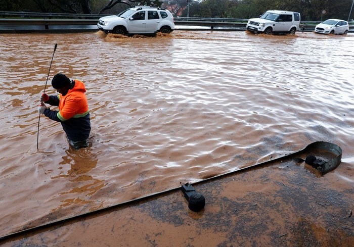 A municipal worker attempts to unclog a flooded road in Newlands during heavy rains in Cape Town, South Africa, 9 July 2024. Reuters/Esa Alexander/File Photo