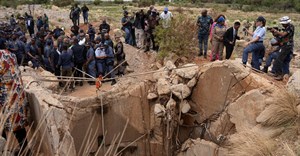 Community members watch as Senzo Mchunu, South African police minister, inspects outside the mineshaft where it is estimated that hundreds of illegal miners are believed to be hiding underground, after police cut off food and water as part of police operations against illegal miners, in Stilfontein. Source: Reuters/Ihsaan Haffejee
