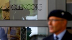 An employee of a private security company stands in front of the logo of commodities trader Glencore during the company's annual shareholder meeting in Cham, Switzerland. Source: Reuters/Arnd Wiegmann