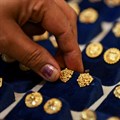 A woman picks a gold earring at a jewellery shop in the old quarters of Delhi. Source: Reuters/Anushree Fadnavis