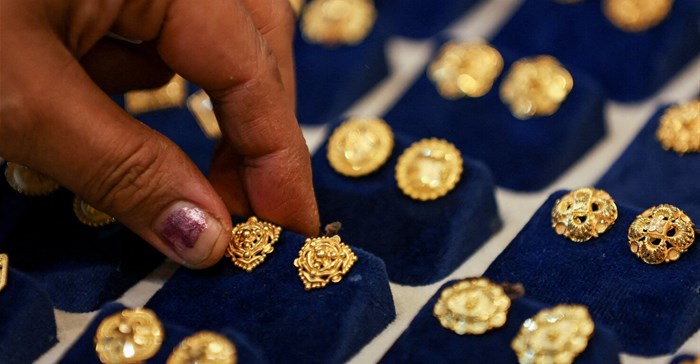A woman picks a gold earring at a jewellery shop in the old quarters of Delhi. Source: Reuters/Anushree Fadnavis