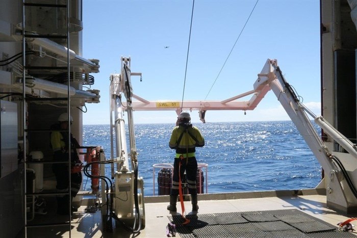 A crew member aboard the SA Agulhas II lowers a device off the side of the ship which can take water samples up to almost seven kilometres below the ocean surface. Scientists aboard the ship said microplastics are found even at these depths.