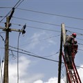 Power officials stand on ladders to fix electric cables along a road in Egbeda district in Nigeria's commercial capital Lagos. Source: Reuters/Akintunde Akinleye