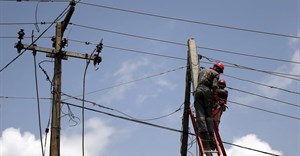 Power officials stand on ladders to fix electric cables along a road in Egbeda district in Nigeria's commercial capital Lagos. Source: Reuters/Akintunde Akinleye