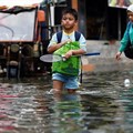 People walk through water at a flooded area affected by rising sea levels and land subsidence in North Jakarta, Indonesia, 20 November 2024. Reuters/Willy Kurniawan/File Photo