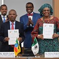 Ethiopian Airlines Group CFO Mensfin Tasew (left) and AfDB Vice President Nnenna Nwabufo display copies of the signed letter of intent. Standing behind them are Ethiopia’s Finance Minister Ahmed Shide (left) and Bank Group President Dr. Akinwumi Adesina (in bow tie)