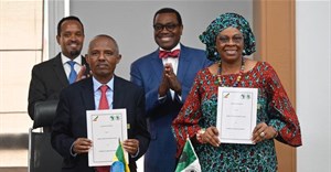 Ethiopian Airlines Group CFO Mensfin Tasew (left) and AfDB Vice President Nnenna Nwabufo display copies of the signed letter of intent. Standing behind them are Ethiopia’s Finance Minister Ahmed Shide (left) and Bank Group President Dr. Akinwumi Adesina (in bow tie)
