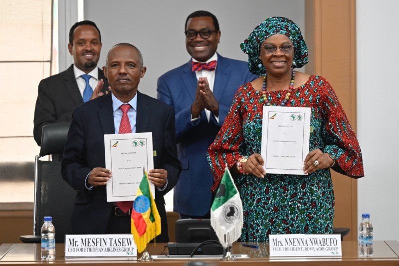 Ethiopian Airlines Group CFO Mensfin Tasew (left) and AfDB Vice President Nnenna Nwabufo display copies of the signed letter of intent. Standing behind them are Ethiopia’s Finance Minister Ahmed Shide (left) and Bank Group President Dr. Akinwumi Adesina (in bow tie)