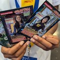 A learner holds up trading cards featuring some of the SuperScientists. This cartoon series, created by Justin Yarrow with a team of local scientists, illustrators and designers, is based on real-life African scientists. Photos: Justin Yarrow/SuperScientists