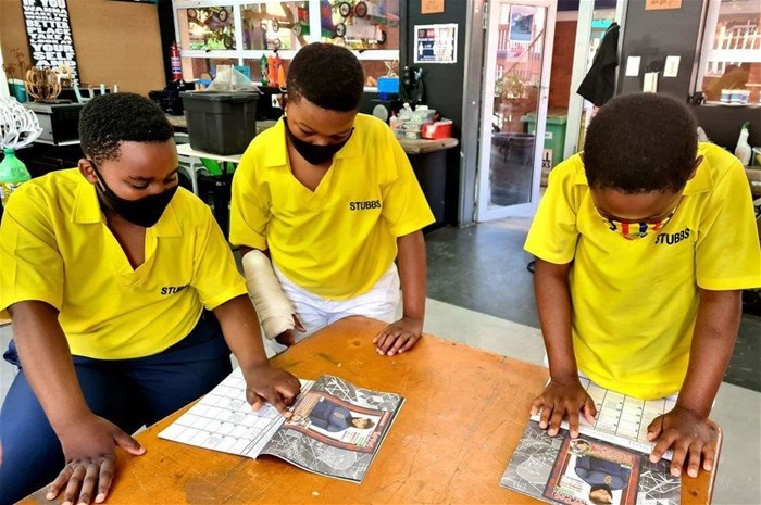 Learners who are part of the CodeMakers organisation run by Justin Yarrow, reading the SuperScientists series.