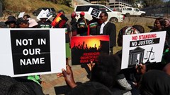Protesters hold placards as lead applicant and lawyer Mzwandile Masuku addresses them outside the court, after a hearing was postponed, in Mbabane, Eswatini, 22 August 2025. Reuters/Zakhele Mabuza