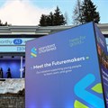 People walk next to a Standard Chartered banner, on the first day of the annual meeting in Davos, Switzerland, 15 January 2024. Reuters/Denis Balibouse/File Photo