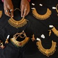 A shop attendant displays gold necklaces for the camera at a jewellery shop in the southern Indian city of Hyderabad, June 30, 2009. Image credit: Reuters/Krishnendu Halder
