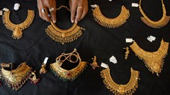 A shop attendant displays gold necklaces for the camera at a jewellery shop in the southern Indian city of Hyderabad, June 30, 2009. Image credit: Reuters/Krishnendu Halder