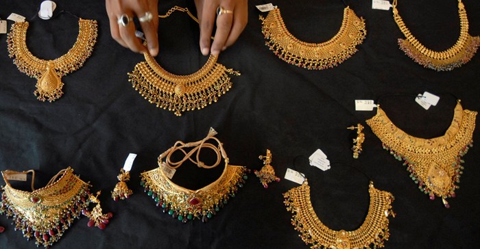 A shop attendant displays gold necklaces for the camera at a jewellery shop in the southern Indian city of Hyderabad, June 30, 2009. Image credit: Reuters/Krishnendu Halder