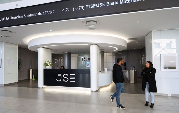 People chat next to the reception of the Johannesburg Stock Exchange (JSE), in Sandton, South Africa, on 1 August 2025. Reuters/Siphiwe Sibeko