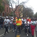 CWP worker Ewart Sithebe, in the yellow jacket with a microphone, led the crowd. Photo: Warren Mabona / GroundUp