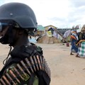 Women walk past a Mozambique soldier inside a camp for the internally displaced in the town of Quitunda, Mozambique, 22 September 2021. Image credit: Reuters/Baz Ratner/File Photo