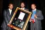 Clement Nhlangwane (Brand Manager of Johnnie Walker) giving Dr. Humphrey Mathe (Eyesizwe) the Mover & Shaker Award on behalf of Mr. Sipho Nkosi. On the right is the Little Black Book editor Tefo Mothibeli.