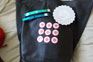 Assistant editor Simone Puterman went a bit dotty with the Gooi stickers on her new handbag in the form of the Biz logo, Also pictured are the wristbands for after-party access and a Loeries-branded doily. Photo: Simone Puterman
