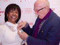 Guest of Honour, Ms. Cheryl Carolus getting pinned Gordon Cook at the launch